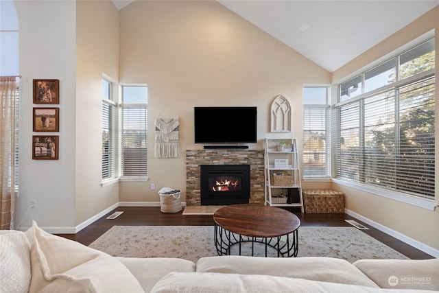 living room featuring high vaulted ceiling, dark hardwood / wood-style flooring, and a fireplace