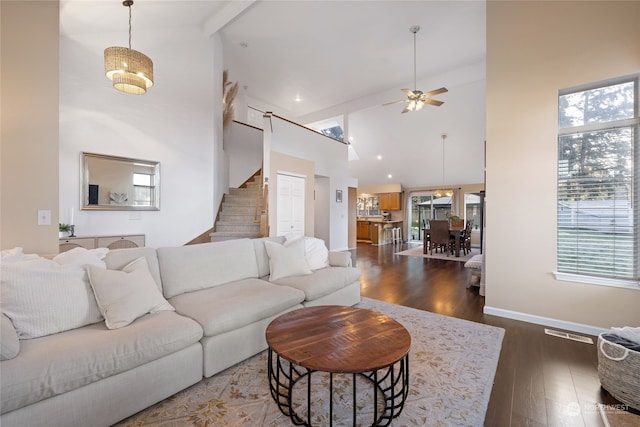 living room with dark hardwood / wood-style floors, high vaulted ceiling, a wealth of natural light, and beam ceiling