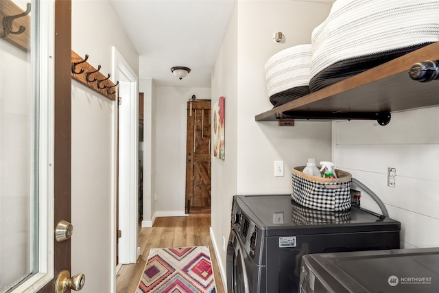 laundry area featuring washing machine and dryer and light hardwood / wood-style floors