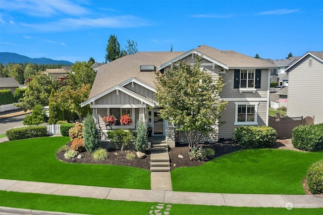 view of front of home with a mountain view, a front lawn, and a porch