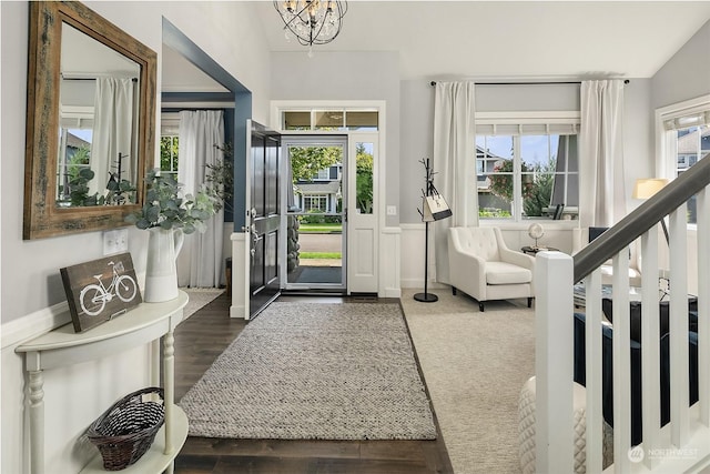 foyer featuring dark wood-type flooring, plenty of natural light, and a chandelier