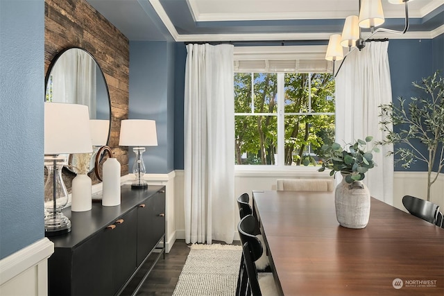 dining room with dark hardwood / wood-style flooring, ornamental molding, a raised ceiling, and an inviting chandelier