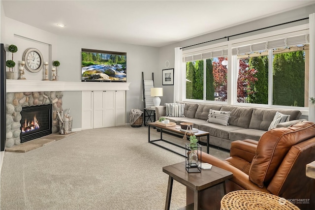 carpeted living room featuring a stone fireplace