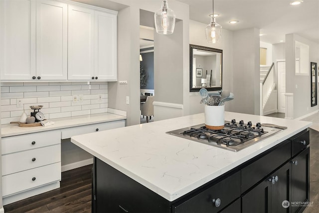 kitchen with pendant lighting, white cabinets, stainless steel gas stovetop, and a kitchen island