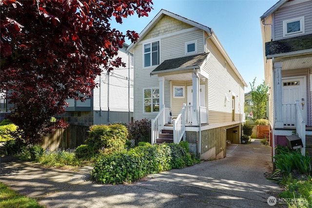 view of front of home with asphalt driveway and fence