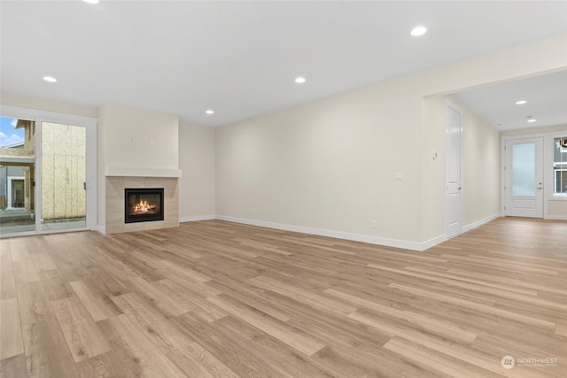 unfurnished living room with a fireplace and light hardwood / wood-style flooring