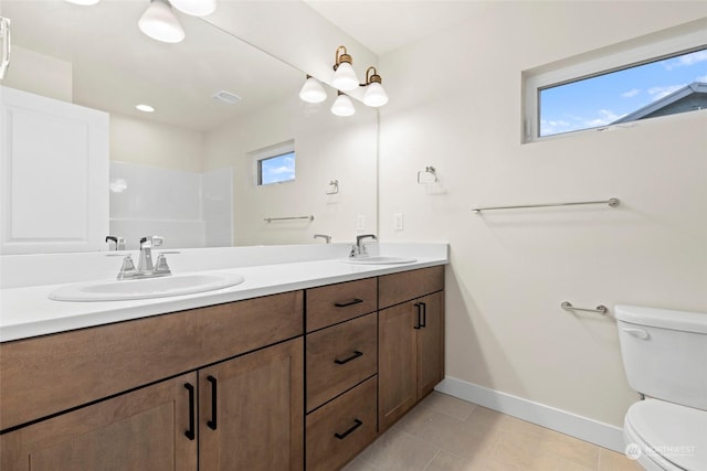 bathroom with tile patterned floors, vanity, toilet, and walk in shower