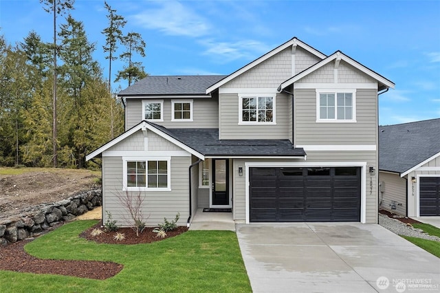 craftsman house featuring a front yard and a garage