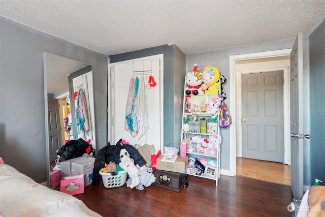 bedroom with a closet, dark hardwood / wood-style floors, and a textured ceiling