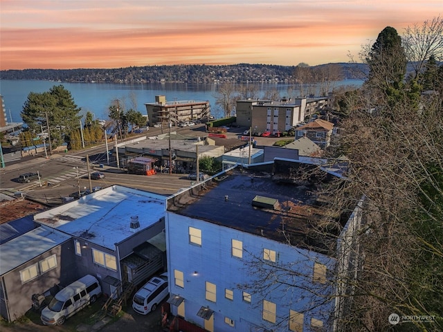 aerial view at dusk featuring a water view