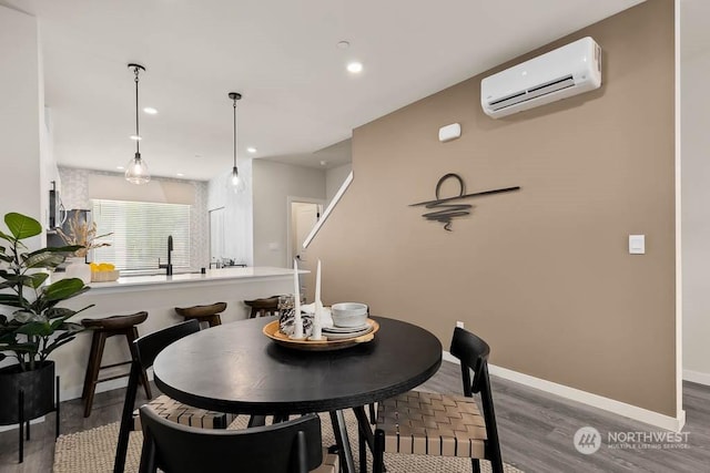 dining space featuring a wall mounted air conditioner and dark hardwood / wood-style flooring