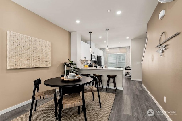 dining space featuring dark hardwood / wood-style flooring and sink