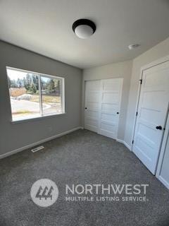 unfurnished bedroom with dark carpet