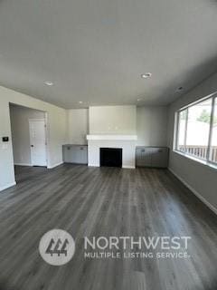 unfurnished living room featuring dark hardwood / wood-style floors