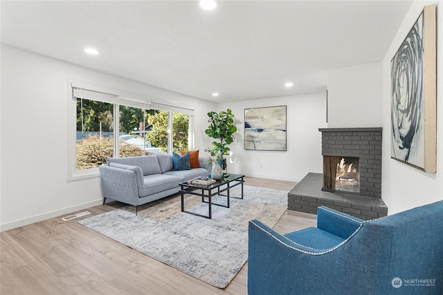 living room featuring hardwood / wood-style floors and a brick fireplace