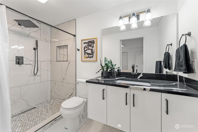 bathroom featuring vanity, toilet, and tiled shower