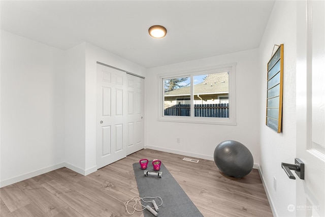 workout area with light hardwood / wood-style floors