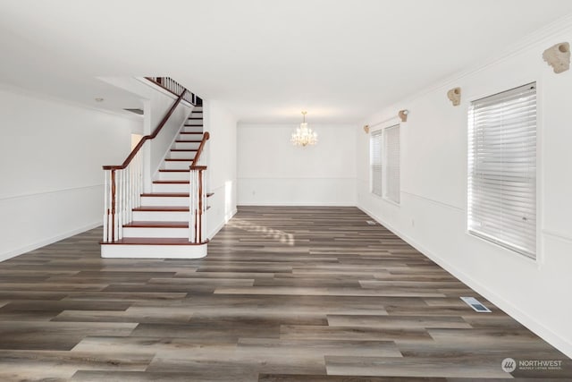 interior space featuring an inviting chandelier, dark wood-type flooring, and ornamental molding