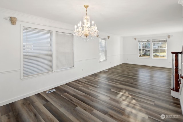 unfurnished dining area with an inviting chandelier, dark hardwood / wood-style floors, and crown molding