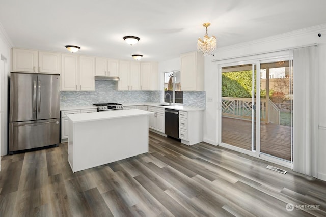 kitchen featuring decorative light fixtures, white cabinets, sink, and appliances with stainless steel finishes