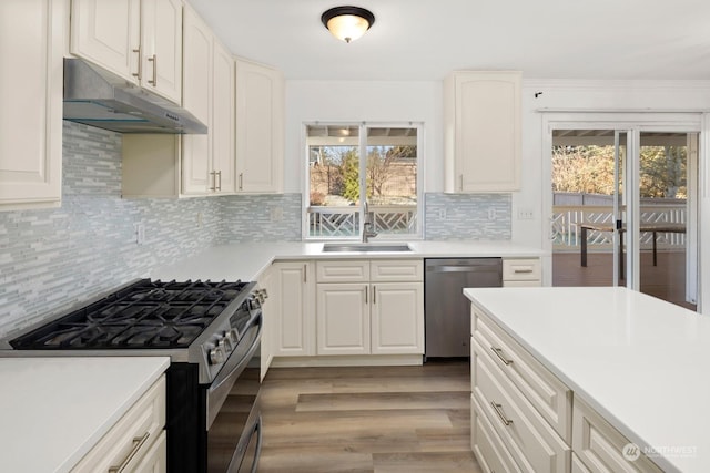 kitchen featuring sink, white cabinetry, appliances with stainless steel finishes, and decorative backsplash