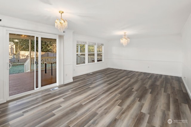 empty room with a chandelier, crown molding, and dark hardwood / wood-style flooring