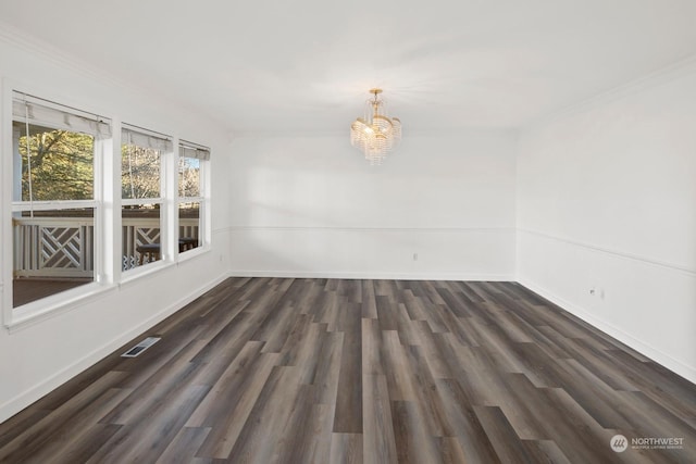 spare room featuring dark hardwood / wood-style flooring and a notable chandelier