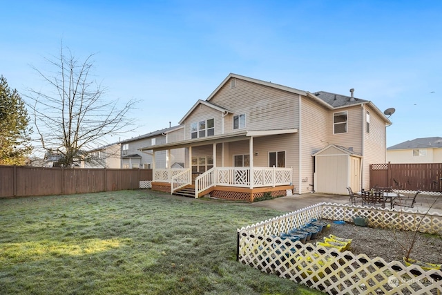 back of property featuring a deck, a yard, a storage shed, and a patio