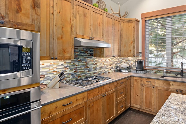 kitchen featuring stainless steel appliances, lofted ceiling, tasteful backsplash, and sink