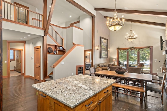 kitchen featuring decorative light fixtures, beam ceiling, a notable chandelier, and a kitchen island