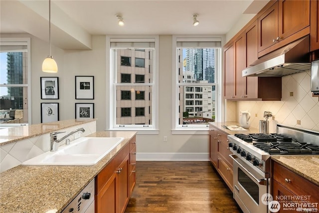 kitchen featuring high end range, decorative light fixtures, dark hardwood / wood-style flooring, sink, and light stone counters