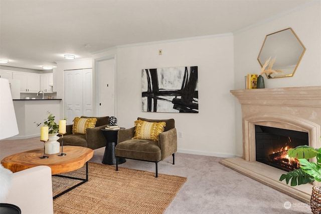 carpeted living room with a premium fireplace, ornamental molding, and sink