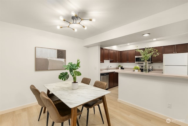 dining space featuring an inviting chandelier and light hardwood / wood-style floors