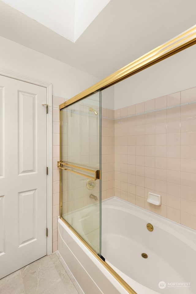 bathroom with tile patterned flooring and shower / bath combination with glass door