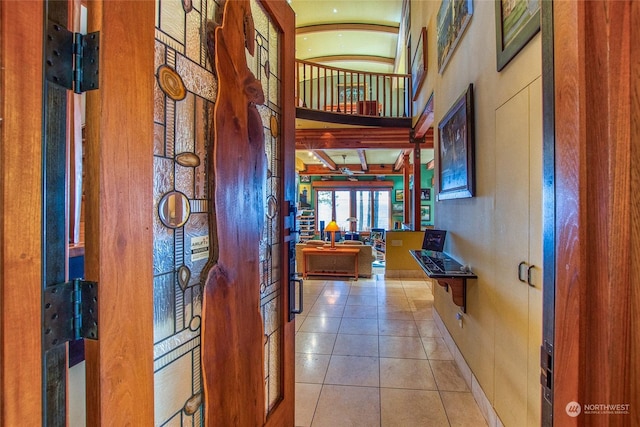 corridor featuring a towering ceiling and tile patterned floors
