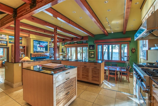 kitchen featuring light tile patterned flooring, beamed ceiling, high end range, a center island, and kitchen peninsula