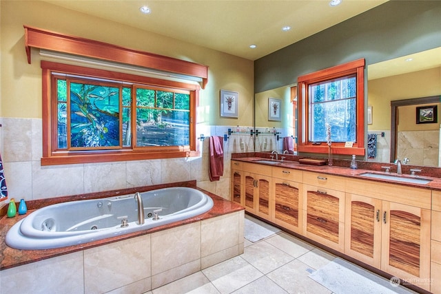 bathroom featuring vanity, tiled tub, and tile patterned flooring