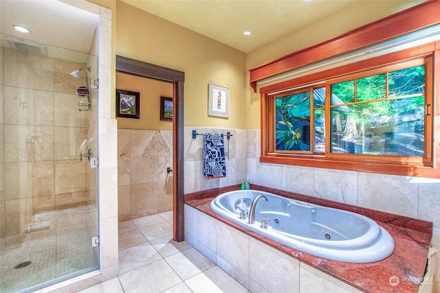 bathroom with tile walls, tile patterned floors, and plus walk in shower