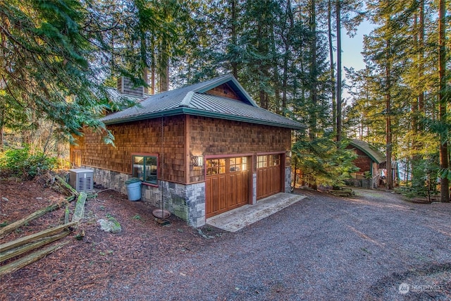 exterior space with a garage and central AC unit
