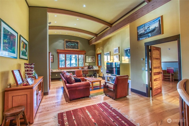 living room with vaulted ceiling with beams and light wood-type flooring