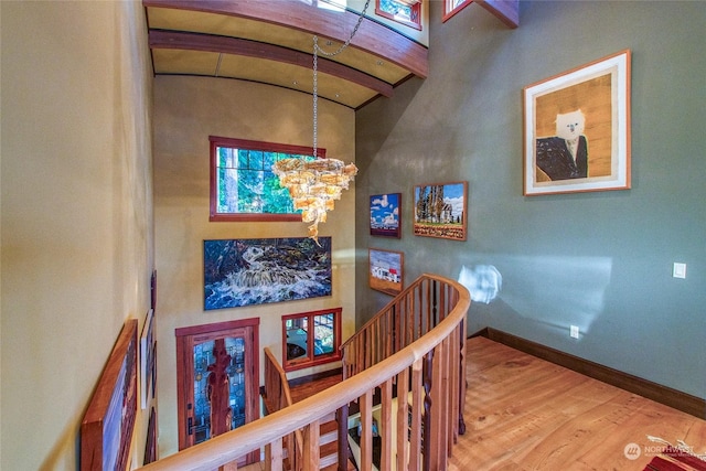 staircase featuring hardwood / wood-style flooring and a notable chandelier