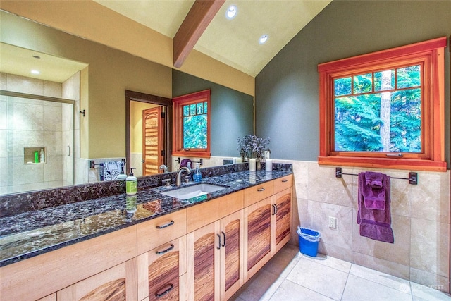 bathroom featuring walk in shower, vaulted ceiling, tile walls, vanity, and tile patterned flooring
