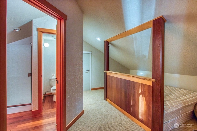 hallway featuring lofted ceiling and carpet