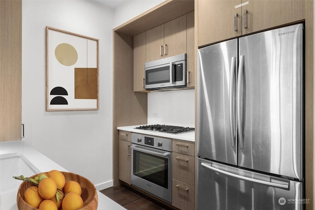 kitchen with appliances with stainless steel finishes and dark hardwood / wood-style floors