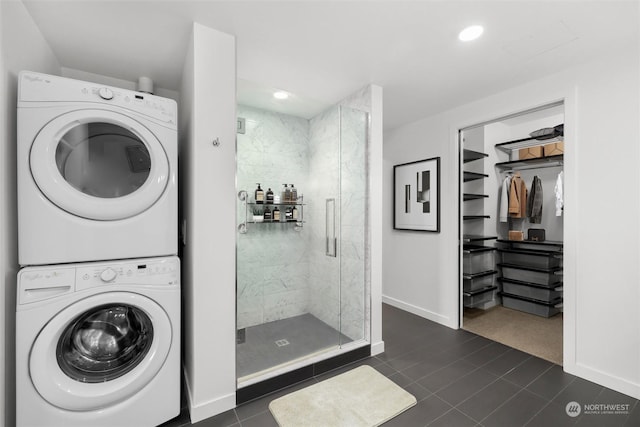 washroom featuring dark tile patterned flooring and stacked washing maching and dryer