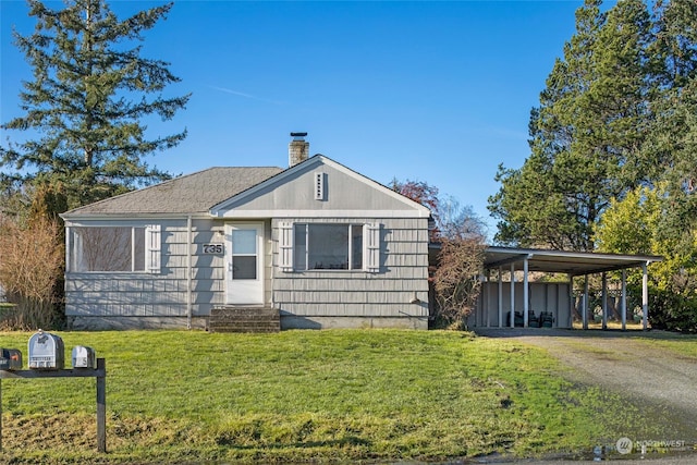 view of front of property with a front lawn and a carport