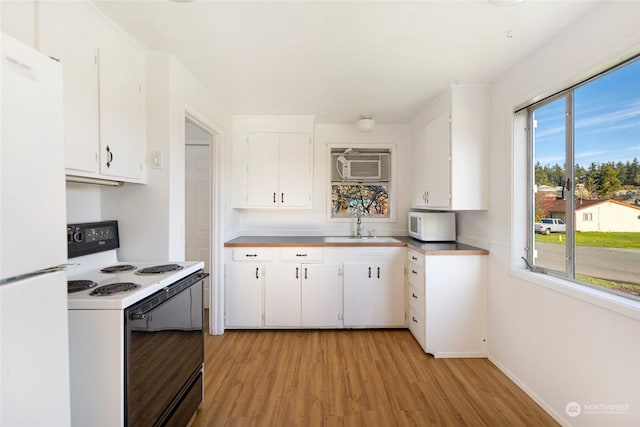735 Harbor St, Friday Harbor, WA 98250 - kitchen featuring white appliances, white cabinets, and light hardwood / wood-style floors