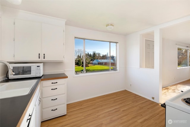 735 Harbor St, Friday Harbor, WA 98250 - kitchen featuring sink, white cabinets, light hardwood / wood-style flooring, and stove
