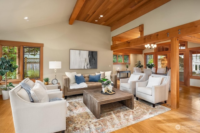 living room featuring light hardwood / wood-style floors, high vaulted ceiling, beamed ceiling, and an inviting chandelier