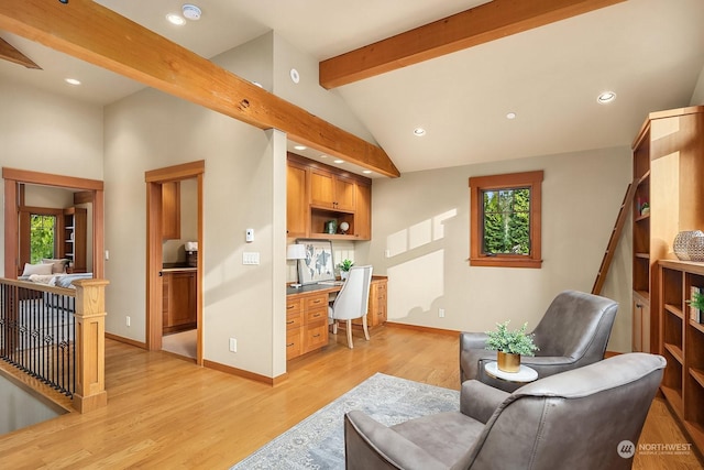 living room with light hardwood / wood-style floors, lofted ceiling with beams, and built in desk